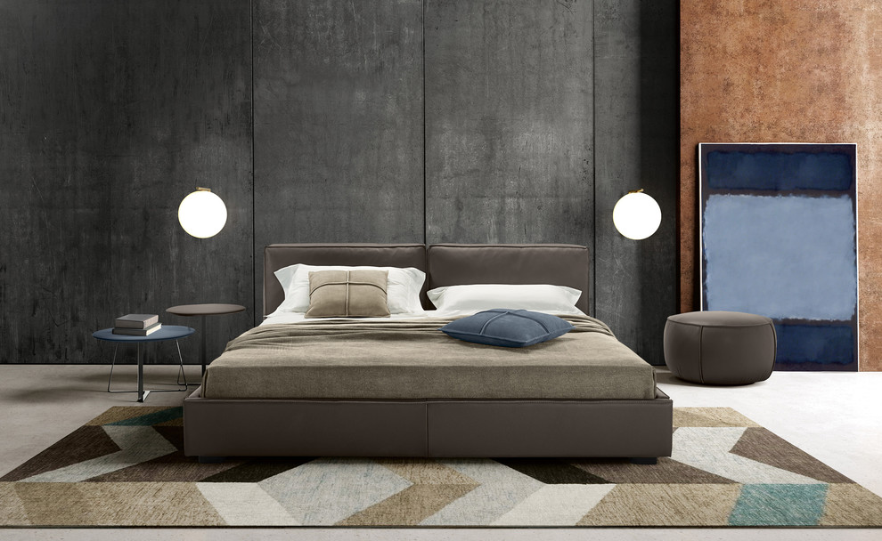 Immagine di una grande camera da letto stile loft moderna con pareti grigie, pavimento in cemento, nessun camino e pavimento grigio