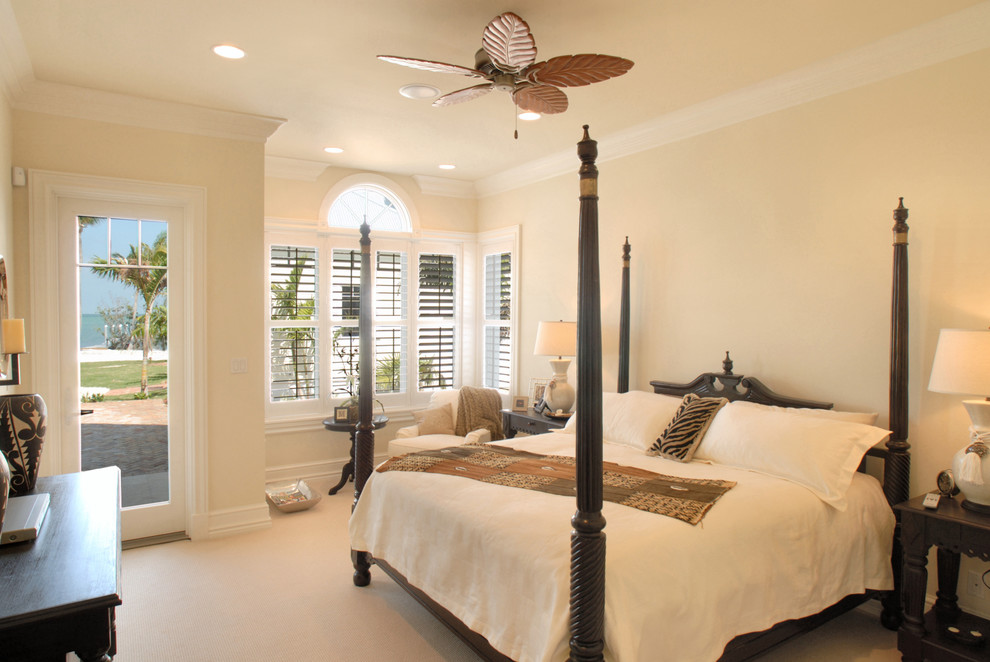 Immagine di una camera da letto tropicale con pareti beige e moquette