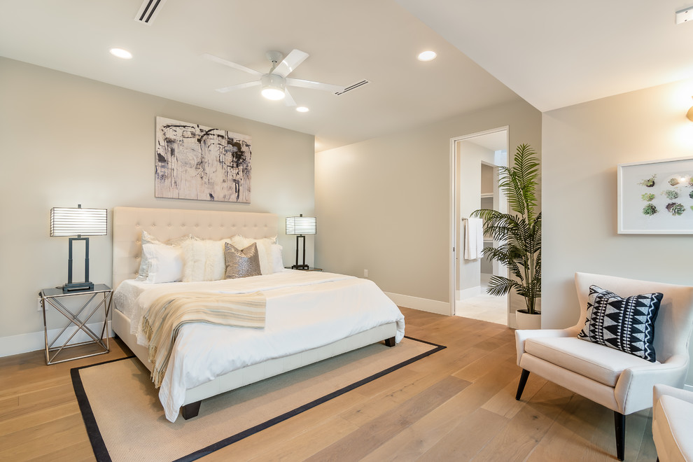 Klassisches Schlafzimmer mit grauer Wandfarbe, hellem Holzboden und beigem Boden in Austin