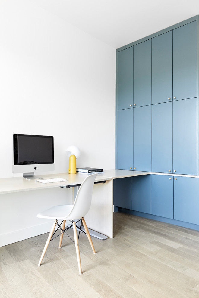 Modelo de habitación de invitados minimalista de tamaño medio con paredes multicolor, suelo de madera en tonos medios y suelo gris