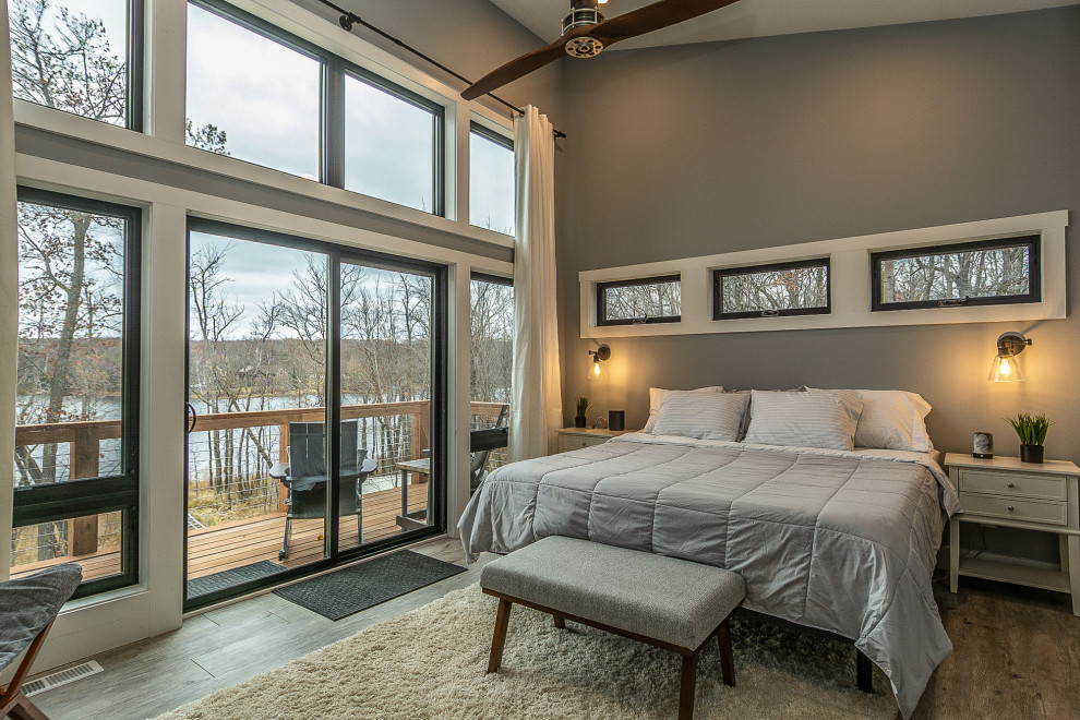 Diseño de dormitorio principal minimalista de tamaño medio con paredes grises, suelo de madera clara y suelo marrón