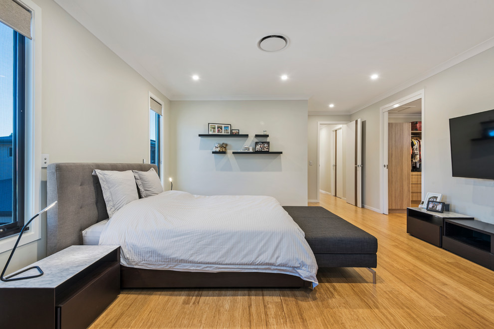 Großes Modernes Hauptschlafzimmer mit beiger Wandfarbe und Bambusparkett in Brisbane