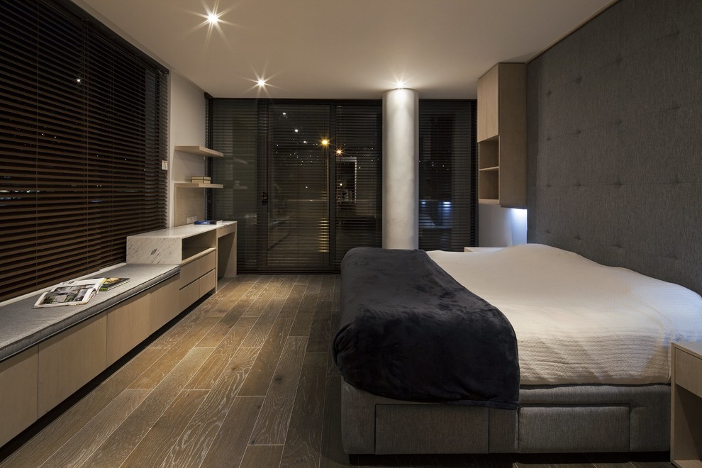 Modelo de dormitorio principal moderno con paredes blancas y suelo de madera oscura