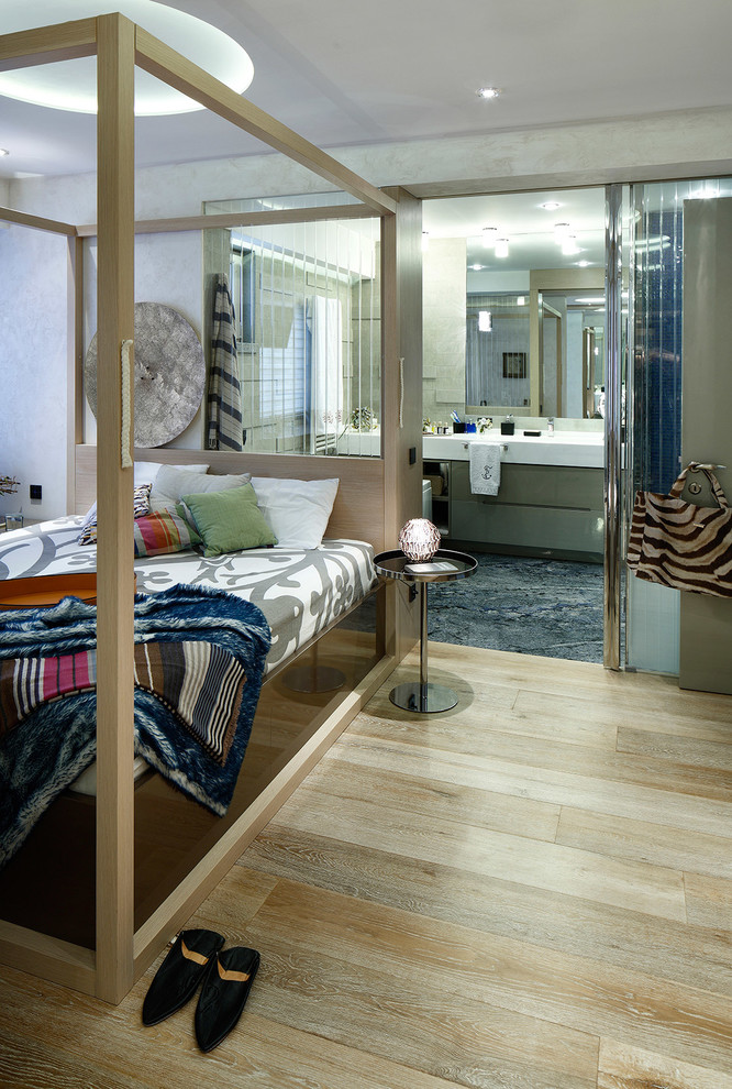 Modelo de dormitorio principal mediterráneo grande sin chimenea con paredes blancas y suelo de madera en tonos medios