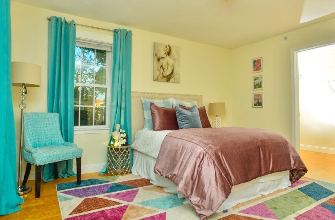 Foto de dormitorio principal contemporáneo de tamaño medio sin chimenea con paredes amarillas, suelo de madera clara y suelo marrón