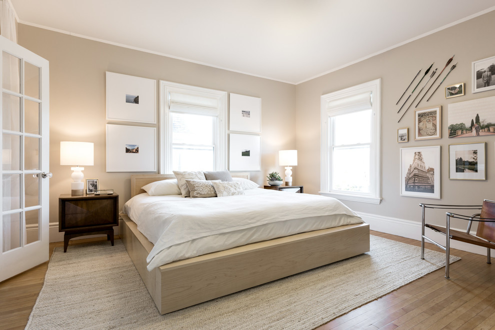 Imagen de dormitorio principal clásico renovado de tamaño medio sin chimenea con paredes beige, suelo de madera en tonos medios y suelo marrón