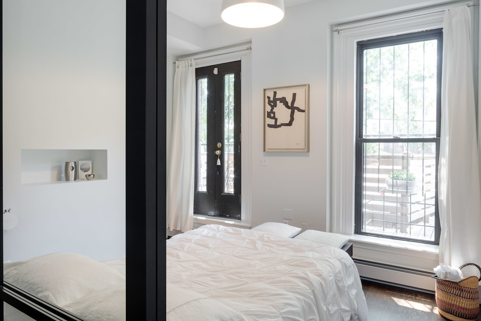 Kleines Modernes Hauptschlafzimmer ohne Kamin mit weißer Wandfarbe, dunklem Holzboden und braunem Boden in Boston