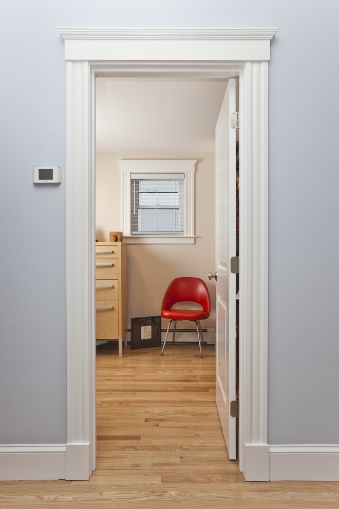 This is an example of a traditional bedroom in Boston with beige walls and light hardwood flooring.