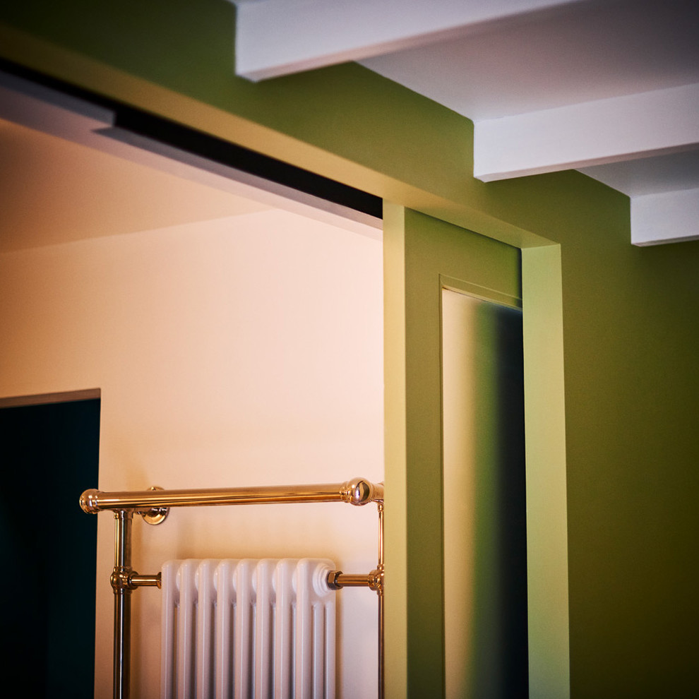 Diseño de habitación de invitados tropical de tamaño medio con paredes verdes, suelo de madera en tonos medios y suelo marrón