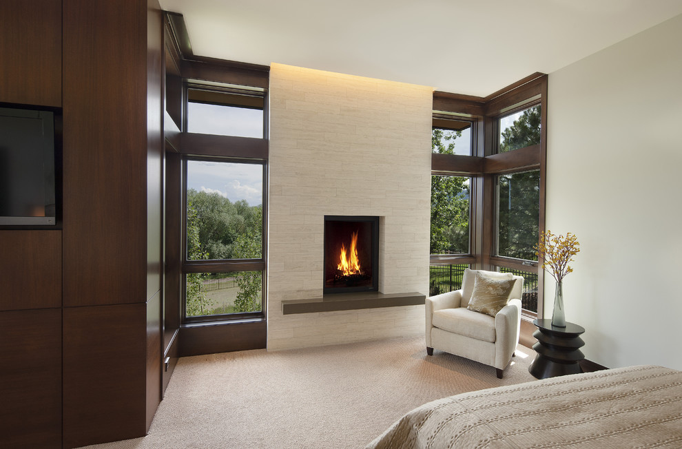 This is an example of a contemporary master bedroom in Denver with carpet, a standard fireplace and a stone fireplace surround.
