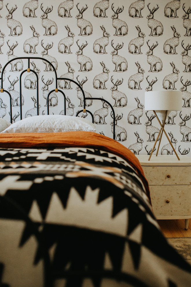 Ispirazione per una camera degli ospiti contemporanea con pareti bianche, pavimento in legno massello medio e pavimento marrone