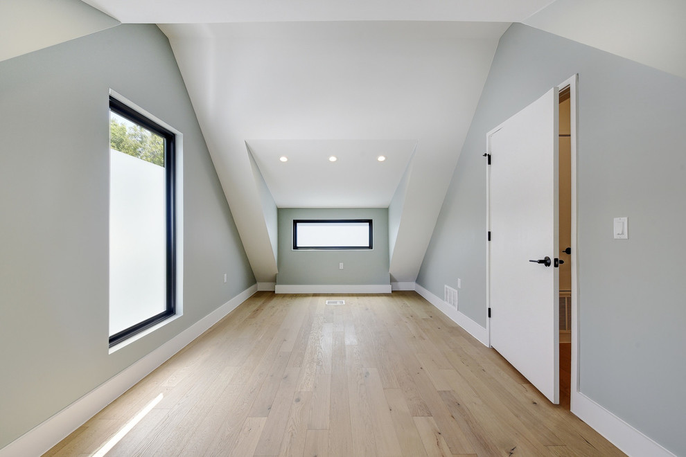 Immagine di una piccola camera da letto stile loft moderna con pareti verdi, parquet chiaro e pavimento marrone
