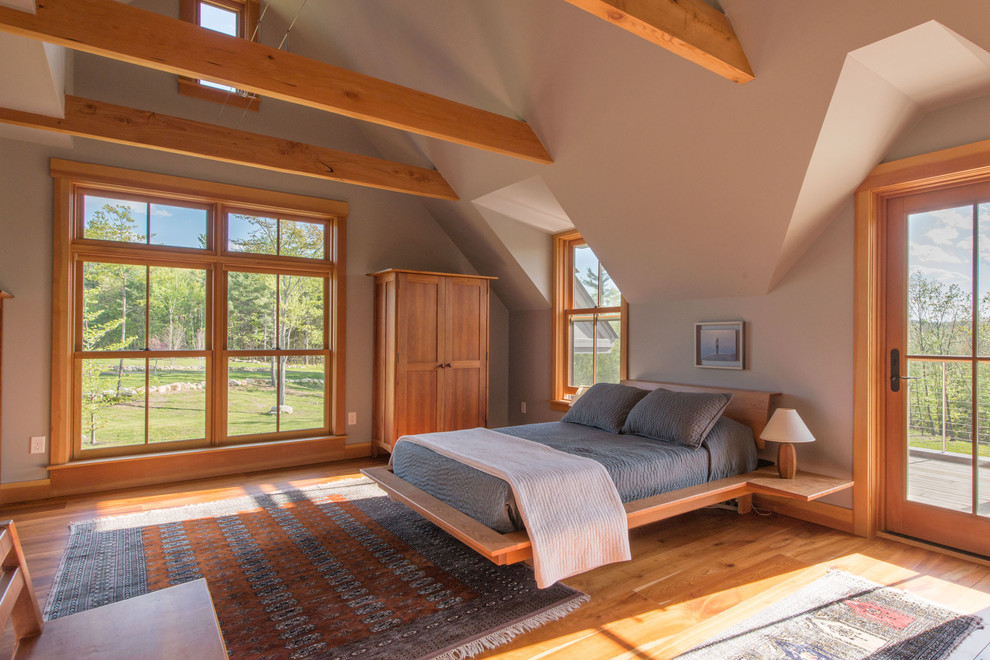 Cette image montre une chambre craftsman avec un mur gris et un sol en bois brun.