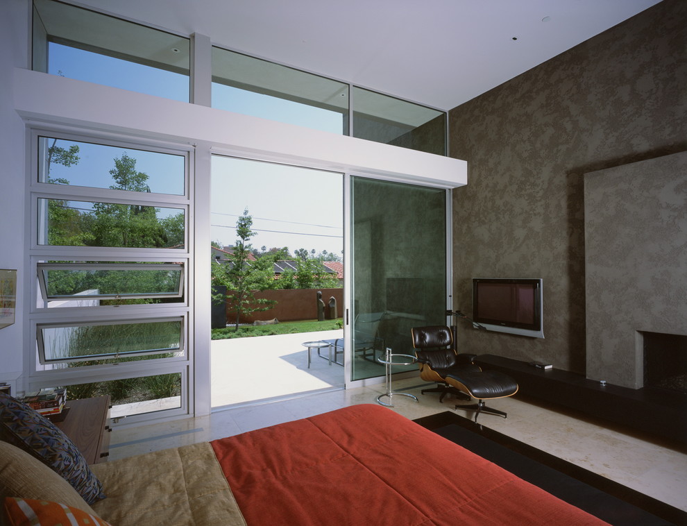 На фото: спальня в стиле модернизм с серыми стенами, стандартным камином и телевизором с