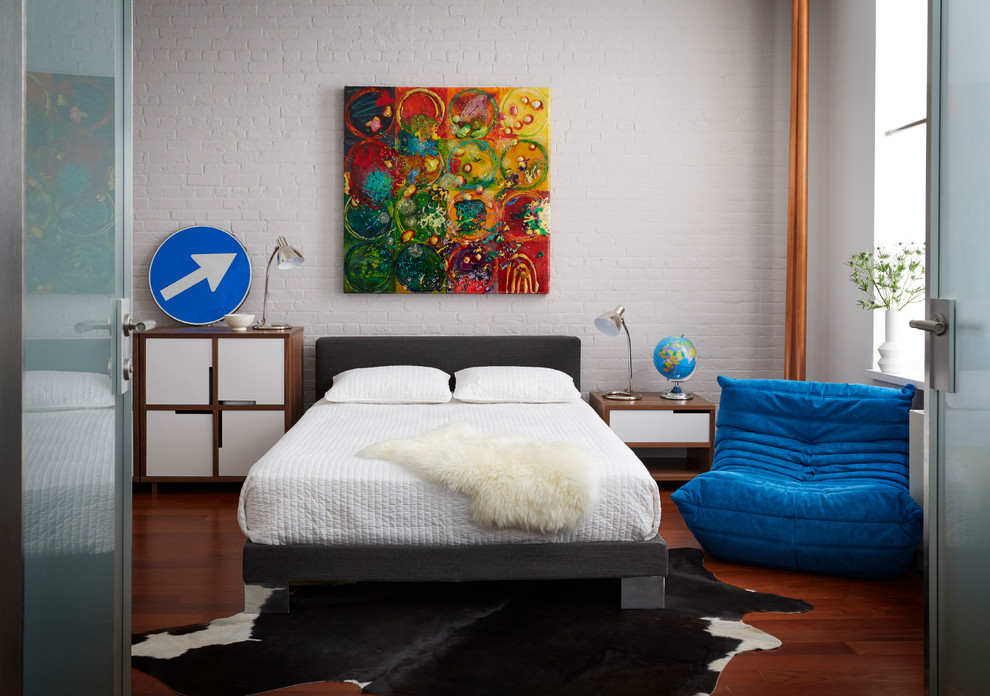 Immagine di una camera da letto contemporanea di medie dimensioni con pareti bianche, pavimento in legno massello medio e pavimento marrone