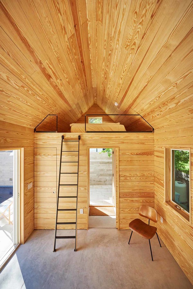 Пример оригинального дизайна: спальня на антресоли в современном стиле с коричневыми стенами, бетонным полом и серым полом