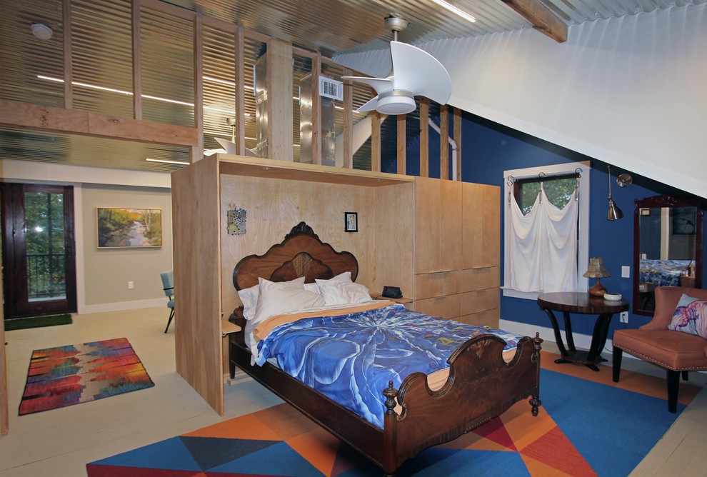 Cette image montre une grande chambre mansardée ou avec mezzanine urbaine avec un mur bleu, un sol en bois brun et un sol multicolore.