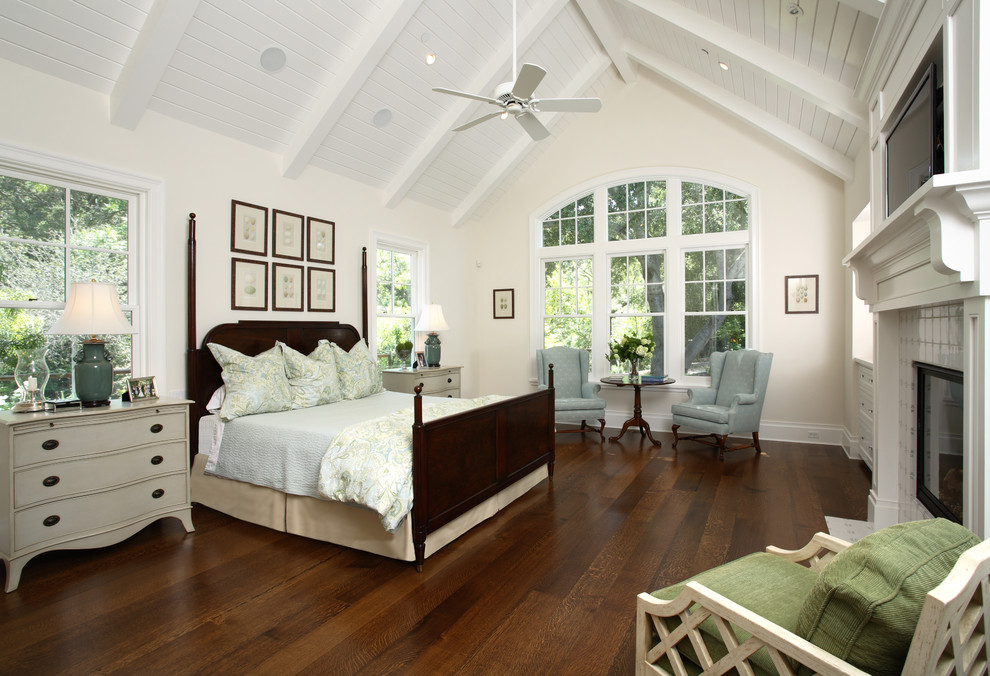 Klassisches Schlafzimmer mit beiger Wandfarbe, dunklem Holzboden, Kamin und gefliester Kaminumrandung in San Francisco