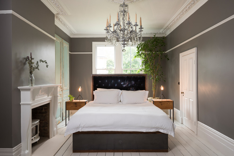 ロンドンにある広いモダンスタイルのおしゃれな主寝室 (グレーの壁、塗装フローリング、薪ストーブ、木材の暖炉まわり、白い床) のレイアウト