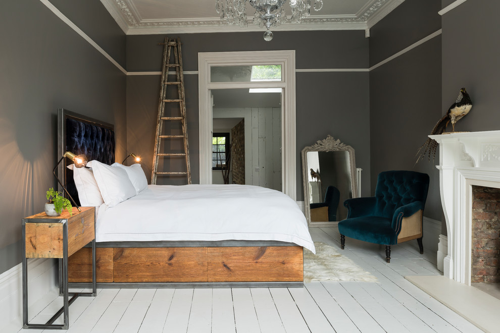 Foto de dormitorio principal moderno grande con paredes grises, suelo de madera pintada, estufa de leña, marco de chimenea de madera y suelo blanco