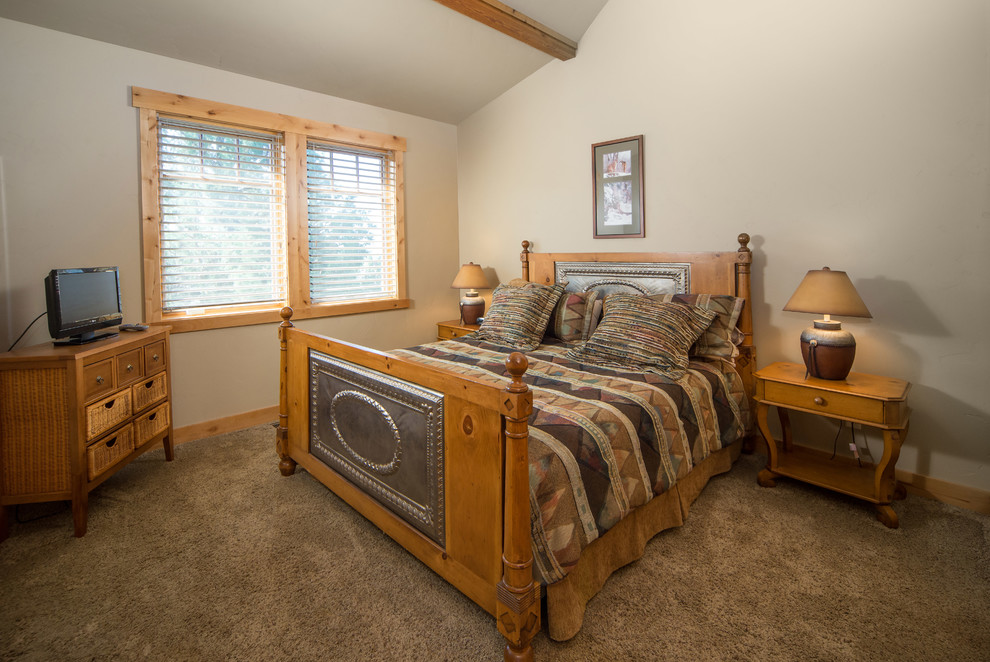 Photo of a rustic bedroom in Other with beige walls and carpet.