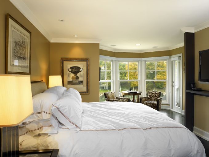 Inspiration for a large classic master bedroom in Cleveland with yellow walls and dark hardwood flooring.