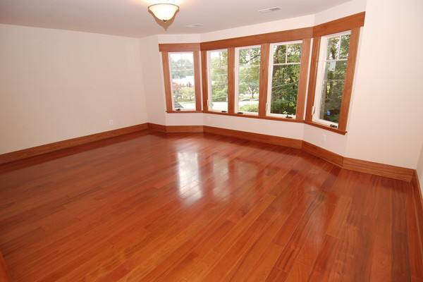 Imagen de habitación de invitados de estilo americano pequeña con paredes beige y suelo de madera en tonos medios