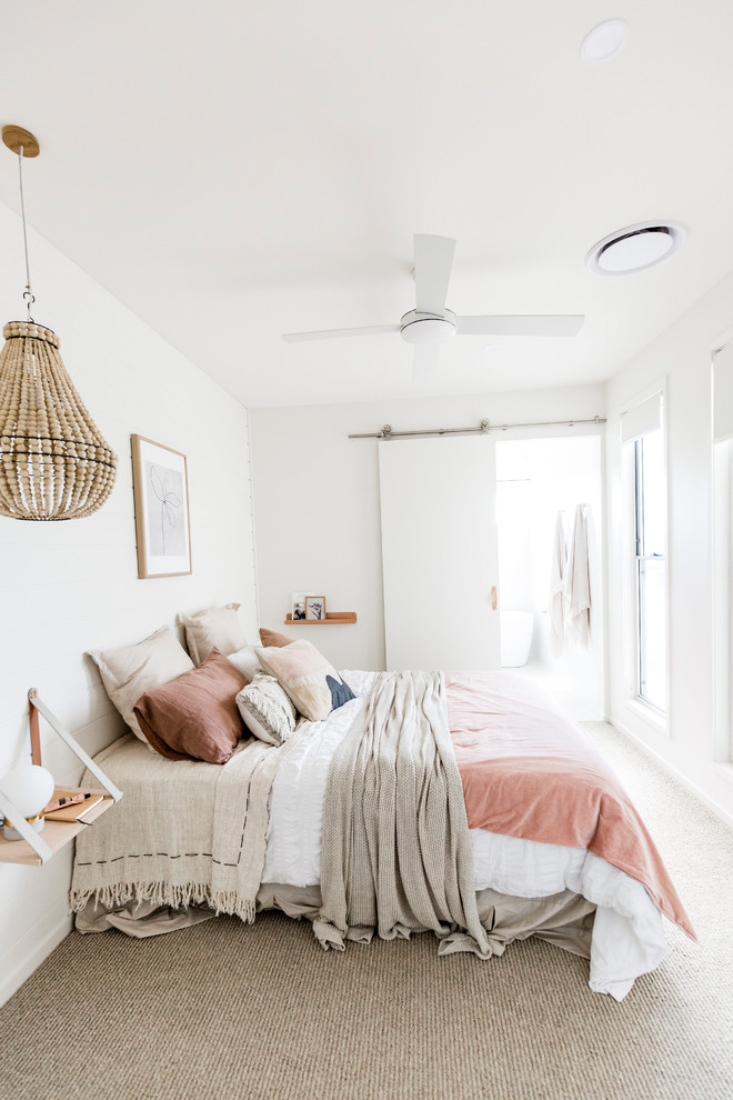 Immagine di una camera matrimoniale stile marinaro con pareti bianche, moquette e pavimento beige