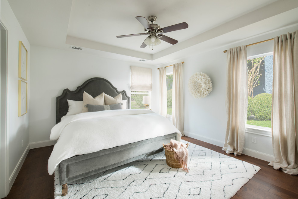 Ejemplo de habitación de invitados actual de tamaño medio sin chimenea con paredes blancas, suelo de madera oscura y suelo marrón