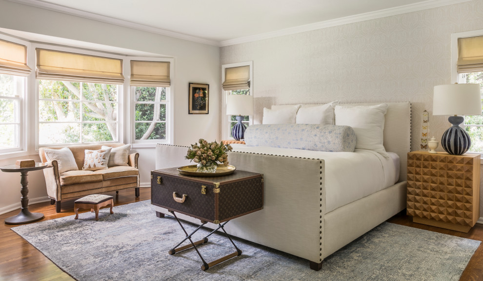 Elegant master medium tone wood floor bedroom photo in Los Angeles with beige walls