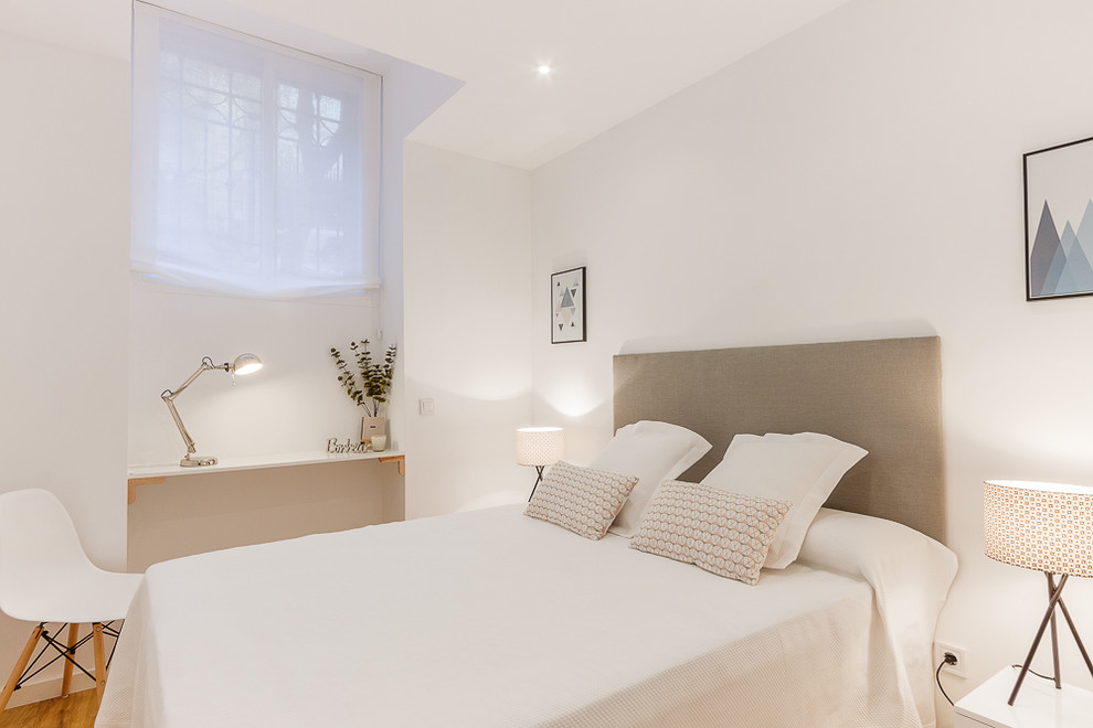 マドリードにある中くらいな北欧スタイルのおしゃれな主寝室 (白い壁、無垢フローリング、暖炉なし、照明) のレイアウト
