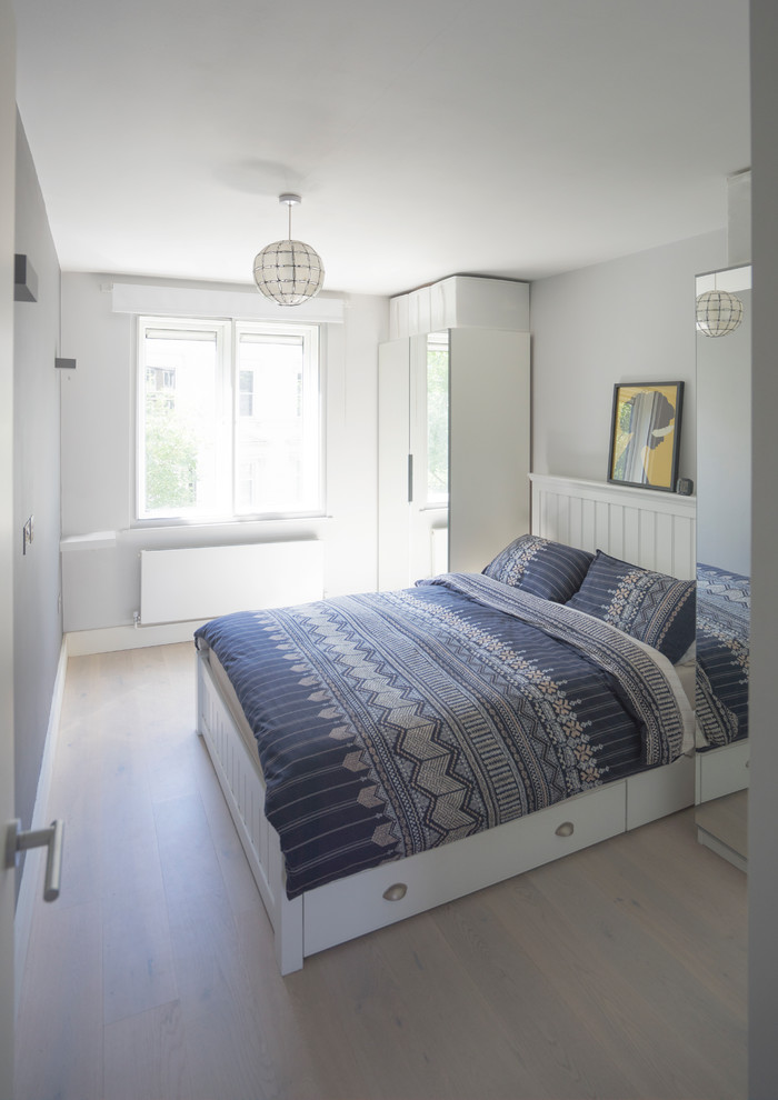 ロンドンにある小さなコンテンポラリースタイルのおしゃれな主寝室 (白い壁、淡色無垢フローリング、白い床) のレイアウト