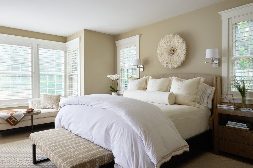 Traditional bedroom in Boston with beige walls, light hardwood flooring and beige floors.