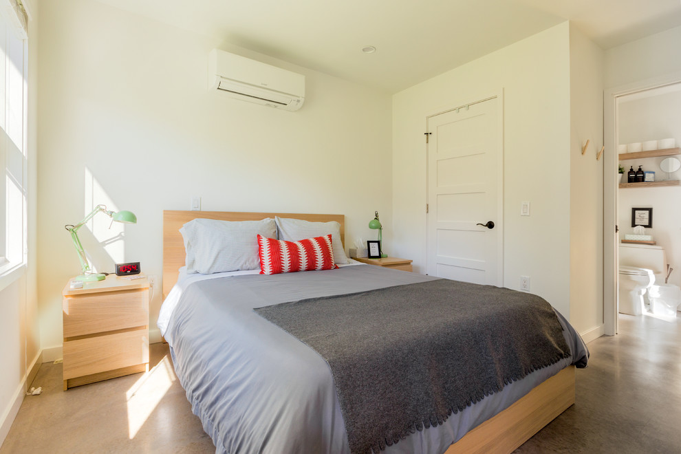 Стильный дизайн: спальня в современном стиле с белыми стенами, бетонным полом и серым полом - последний тренд