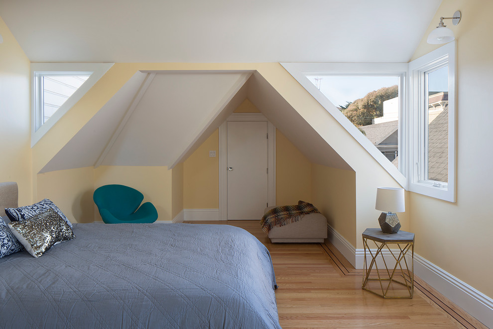 Foto de dormitorio principal campestre de tamaño medio sin chimenea con paredes amarillas y suelo de madera en tonos medios