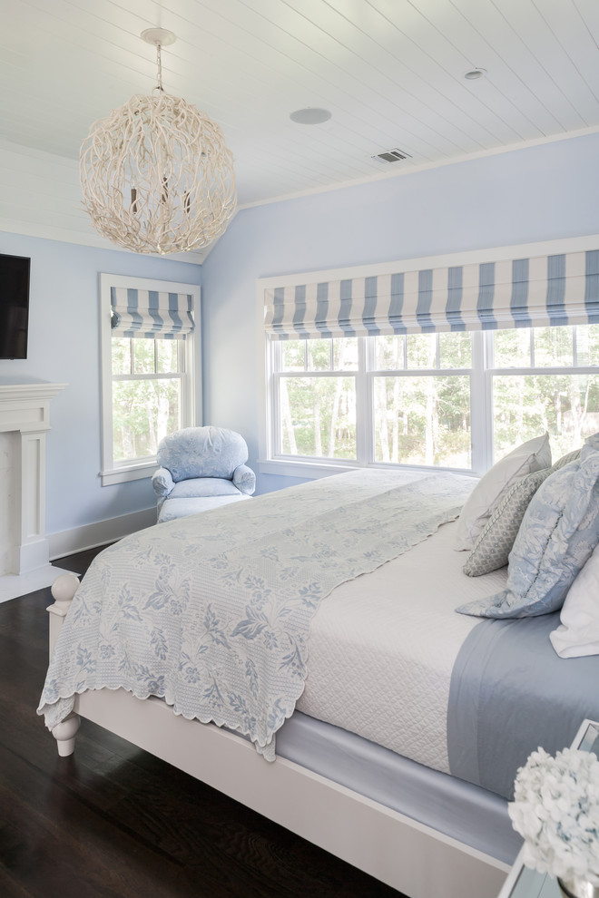 Ispirazione per una camera matrimoniale stile marino di medie dimensioni con pareti blu, parquet scuro e camino classico