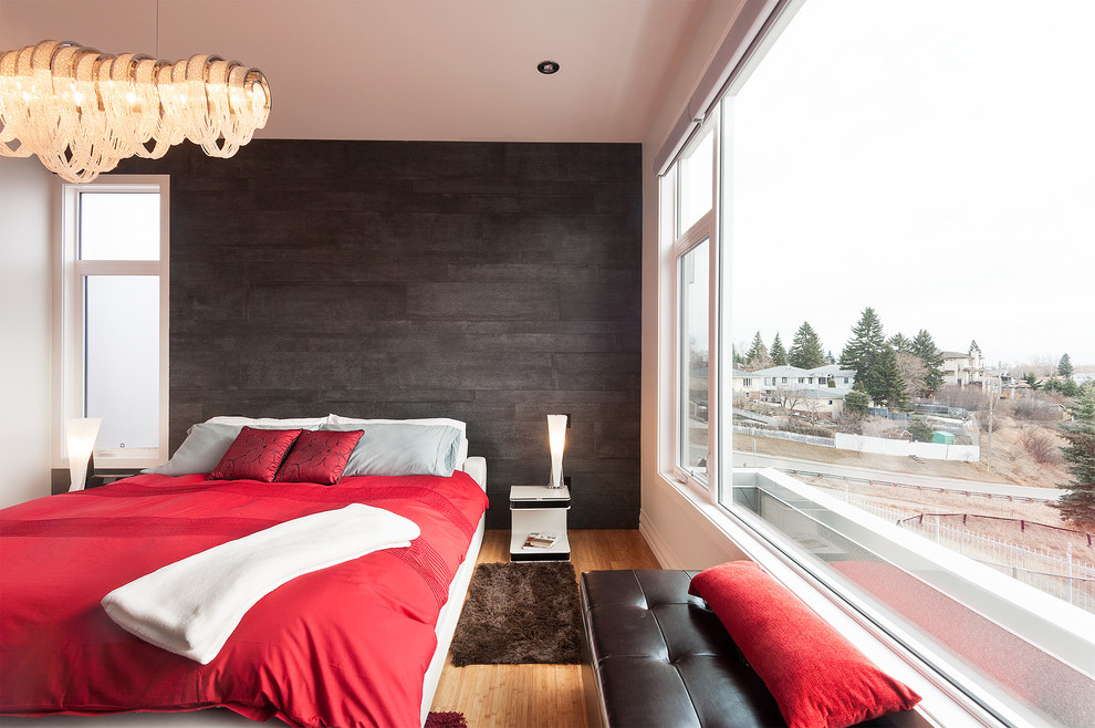 На фото: хозяйская спальня в стиле модернизм с серыми стенами, полом из бамбука и фасадом камина из камня