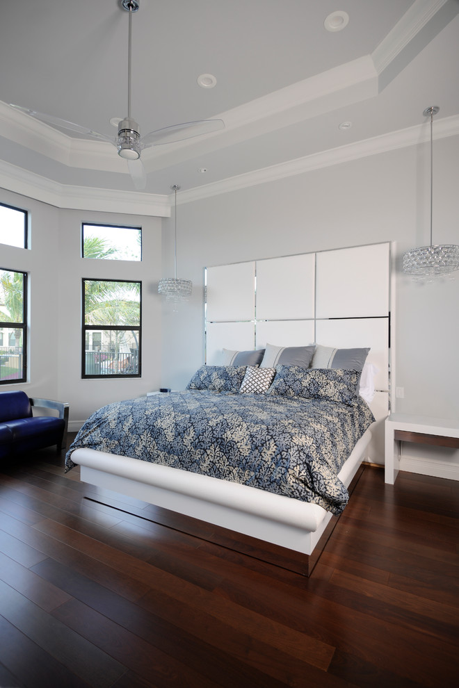 На фото: большая хозяйская спальня в современном стиле с серыми стенами, темным паркетным полом и коричневым полом без камина