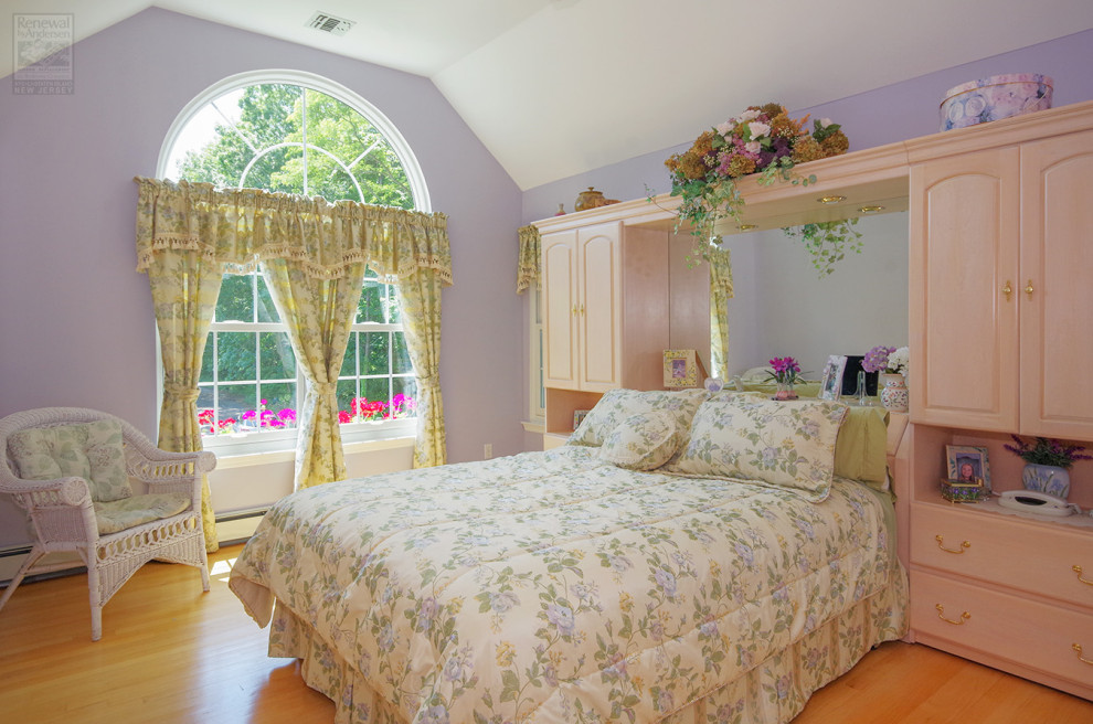 Idées déco pour une chambre parentale de taille moyenne avec un mur violet, un sol en bois brun, aucune cheminée et un plafond voûté.
