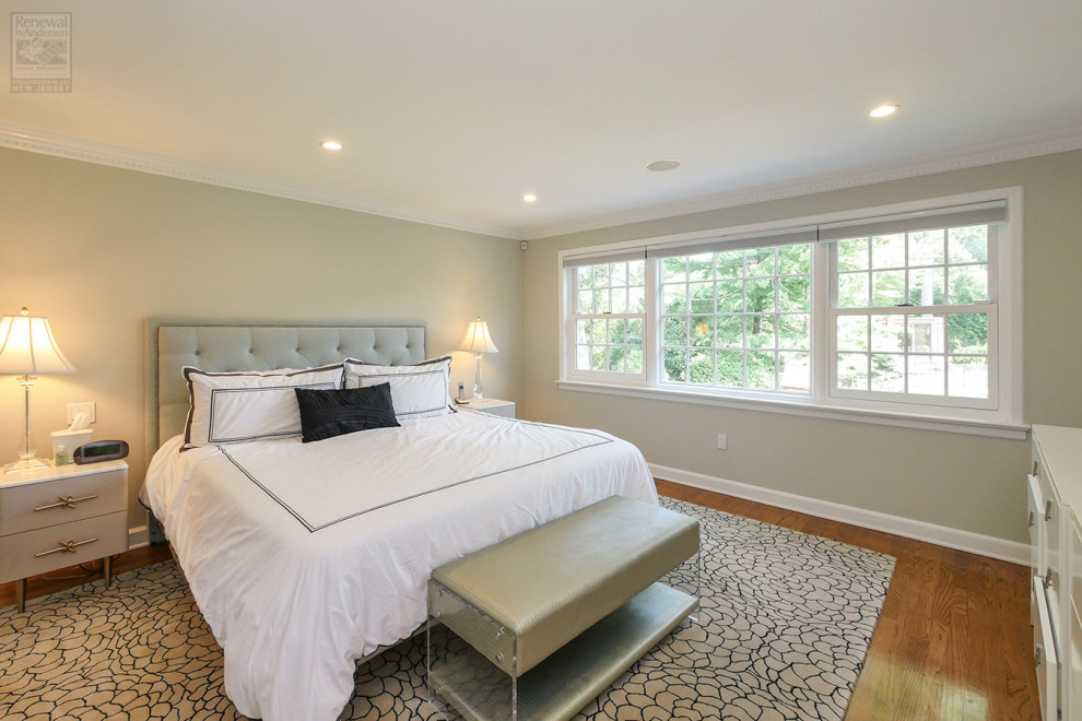 Diseño de dormitorio principal grande sin chimenea con paredes grises, suelo de madera en tonos medios y suelo multicolor