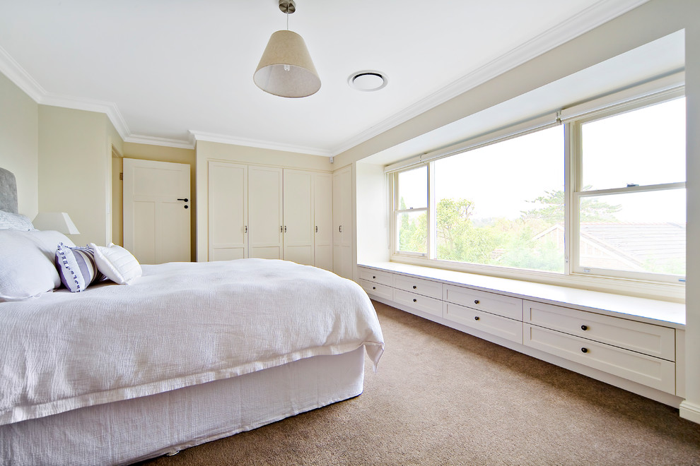 This is an example of a medium sized traditional master bedroom in Sydney with beige walls, carpet, no fireplace and beige floors.