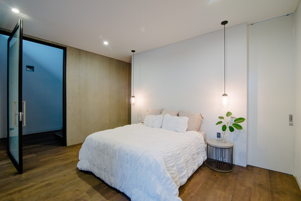 Diseño de dormitorio principal contemporáneo grande con paredes blancas y suelo de madera oscura