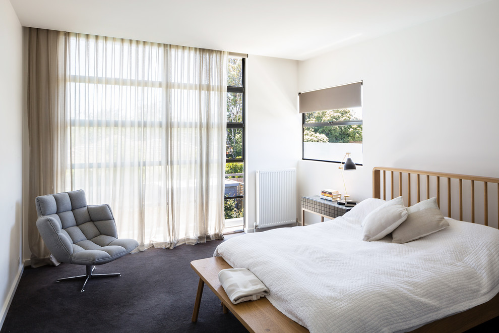 Modernes Gästezimmer mit weißer Wandfarbe, Teppichboden und grauem Boden in Melbourne
