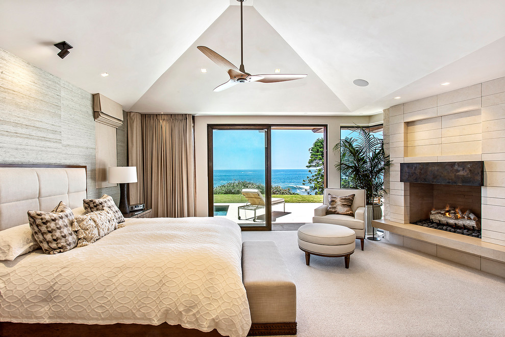 Medium sized contemporary master bedroom in Los Angeles with carpet, a tiled fireplace surround, beige walls, a corner fireplace, beige floors and feature lighting.