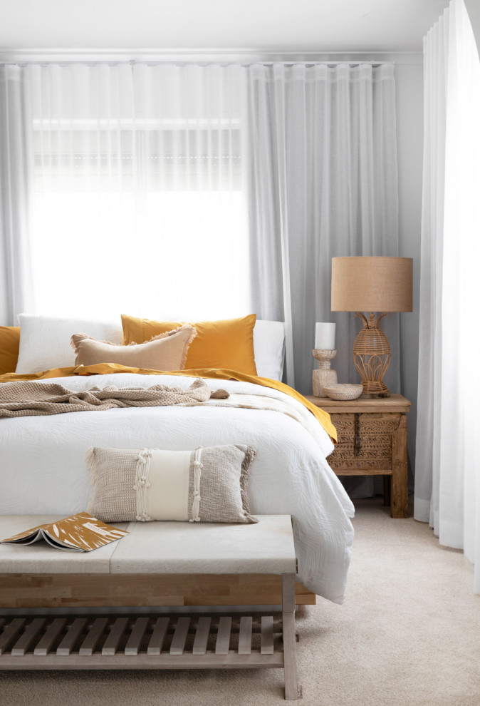 Imagen de dormitorio principal costero grande con moqueta, suelo beige y paredes beige