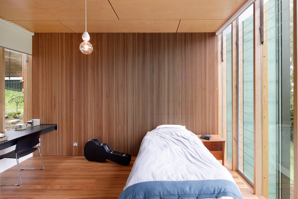 Idées déco pour une chambre d'amis contemporaine avec un sol en bois brun.
