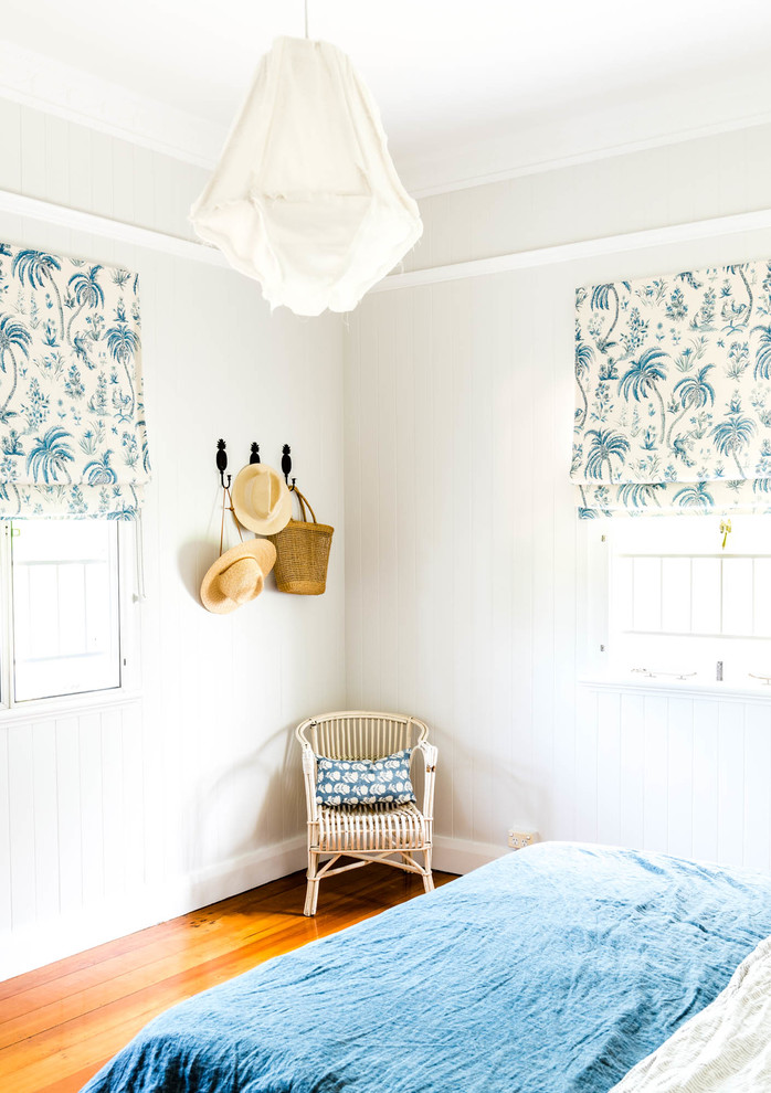 Idée de décoration pour une chambre parentale nordique de taille moyenne avec un mur blanc, parquet foncé et un sol marron.