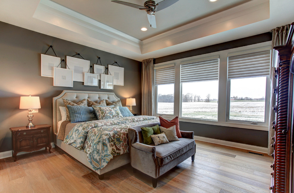 Ejemplo de dormitorio tradicional con paredes grises, suelo de madera en tonos medios y suelo marrón
