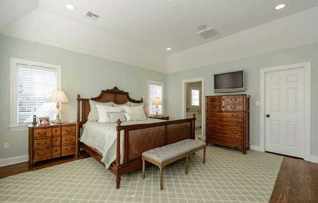 Foto de dormitorio principal tradicional grande sin chimenea con paredes verdes y suelo de madera en tonos medios