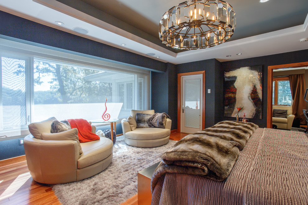 Ispirazione per una camera matrimoniale design con pareti blu e pavimento in legno massello medio